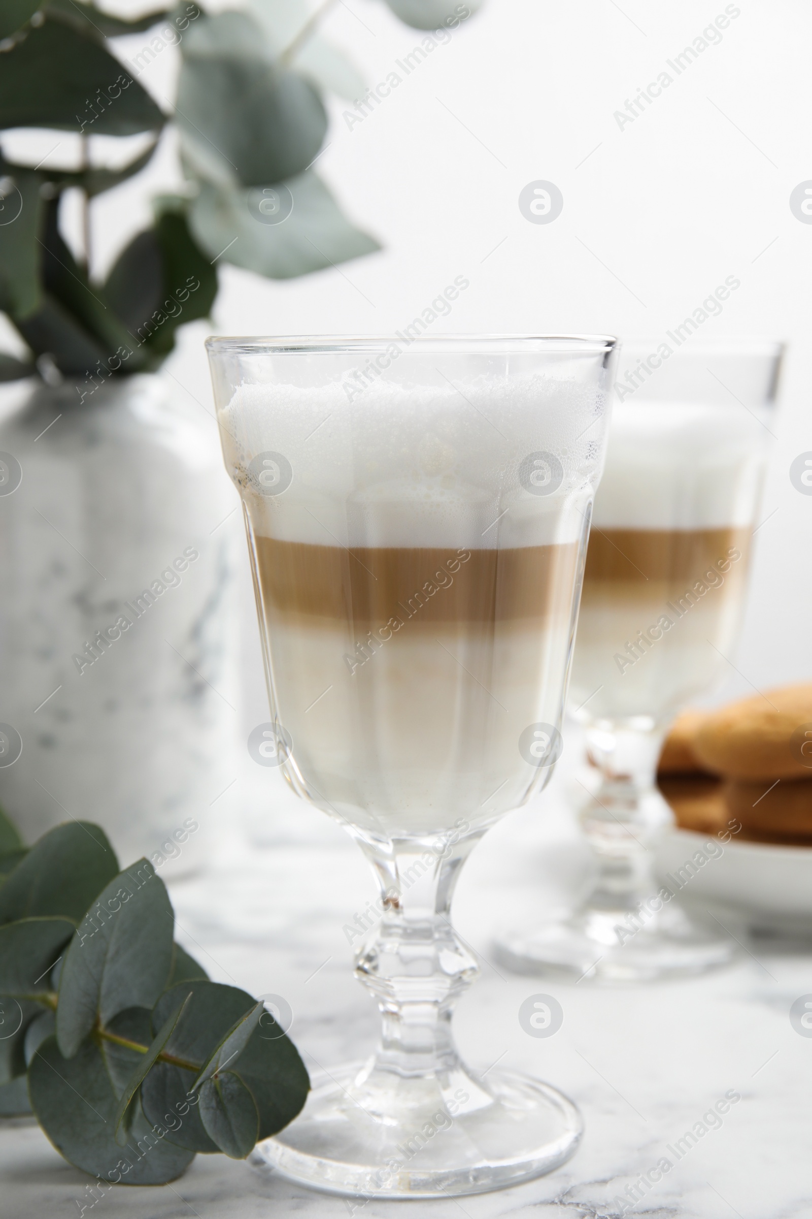 Photo of Delicious latte macchiato and tasty cookies on white marble table