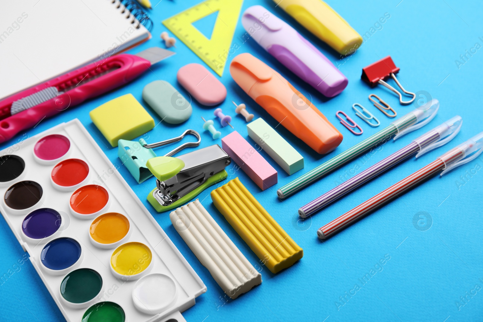 Photo of Different school stationery on light blue background. Back to school