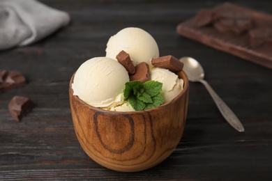 Photo of Delicious vanilla ice cream with chocolate and mint served on wooden table