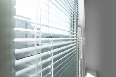 Photo of Stylish window with horizontal blinds in room, closeup