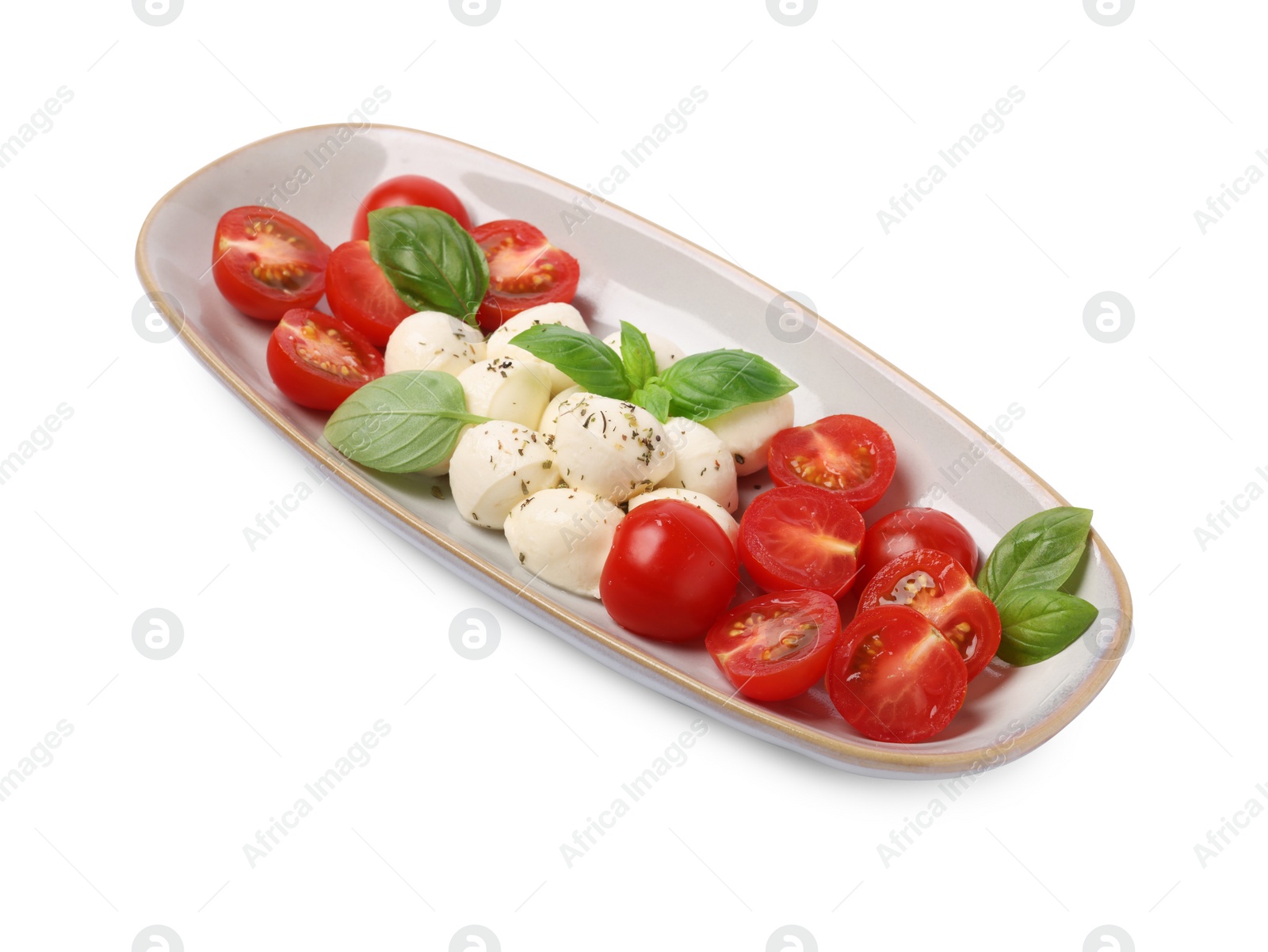 Photo of Plate of delicious Caprese salad with tomatoes, mozzarella, basil and spices isolated on white