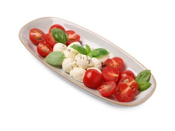 Plate of delicious Caprese salad with tomatoes, mozzarella, basil and spices isolated on white