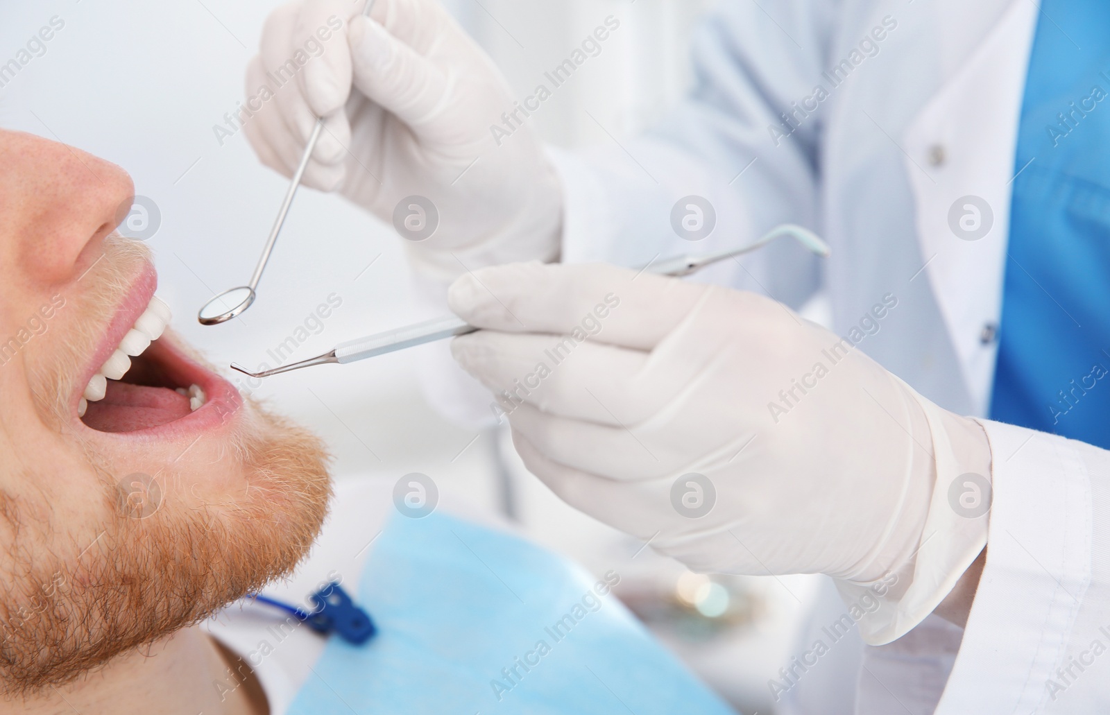 Photo of Dentist examining patient's teeth in modern clinic, closeup