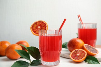 Photo of Tasty sicilian orange juice and fruits on white wooden table