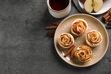 Photo of Freshly baked apple roses on grey table, flat lay. Space for text