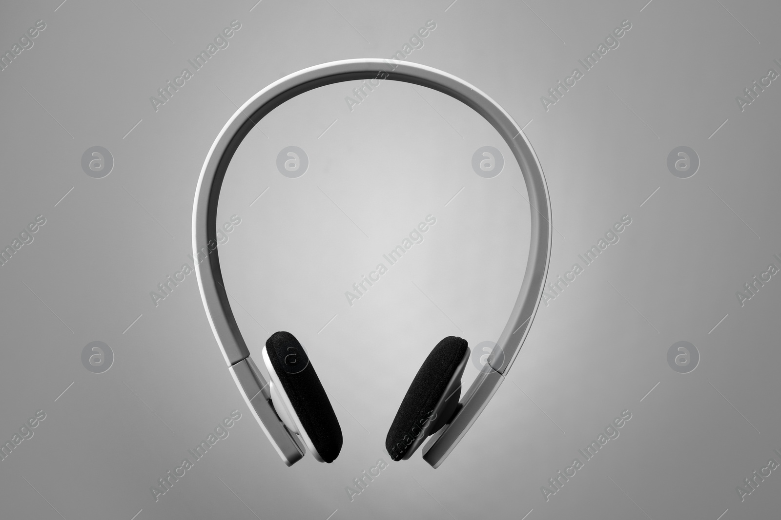 Photo of Stylish modern headphones with earmuffs on color background