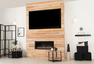 Photo of Living room interior with decorative fireplace in wooden wall