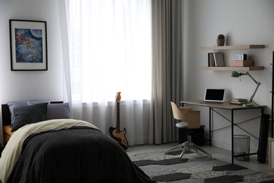 Photo of Modern teenager's room interior with workplace and bed