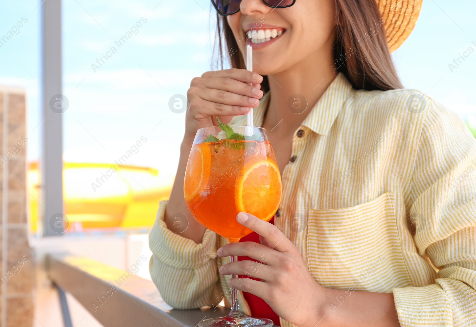 Photo of Woman with glass of refreshing drink outdoors, closeup