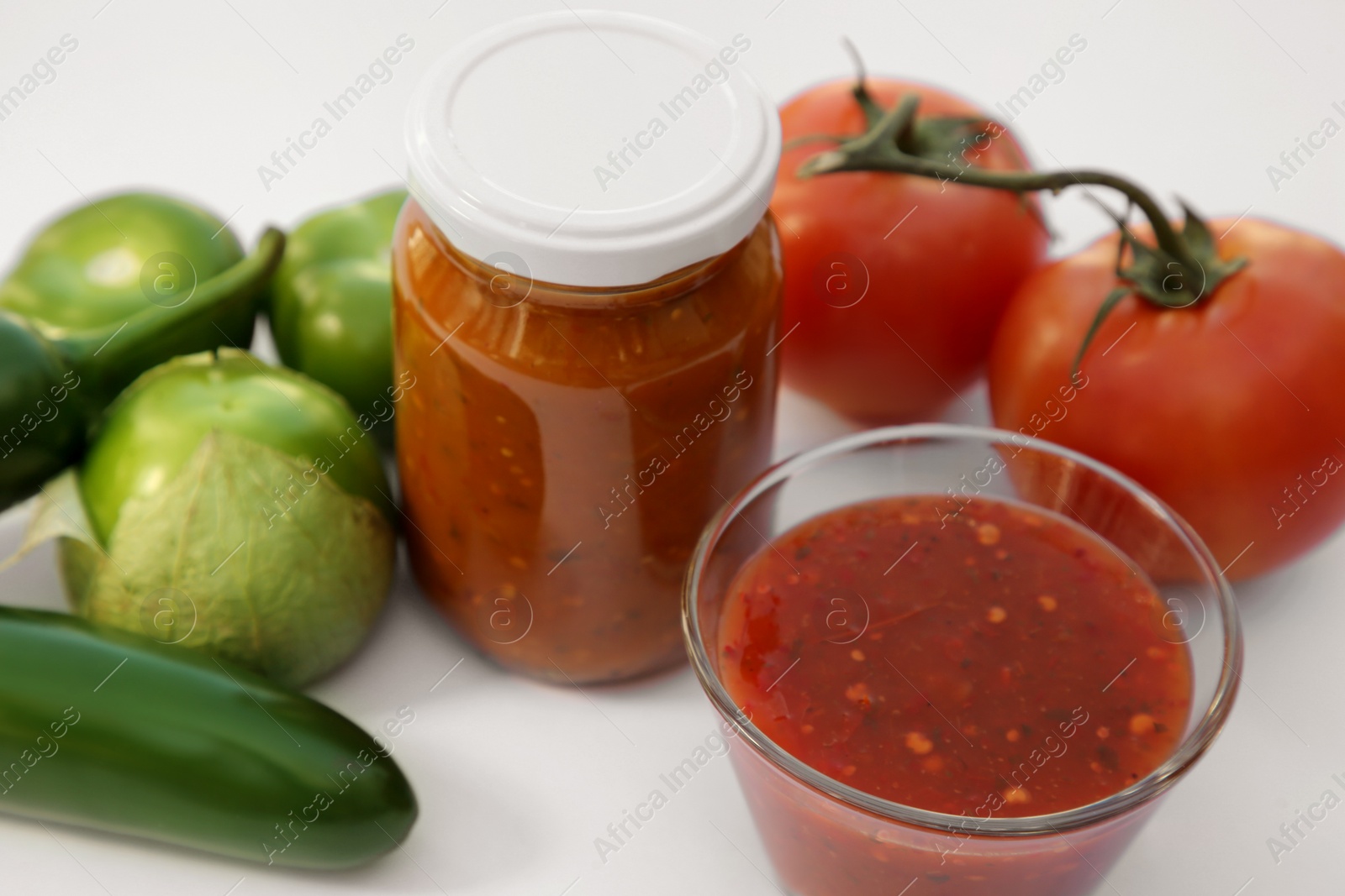 Photo of Delicious salsa sauce and ingredients on white background, closeup