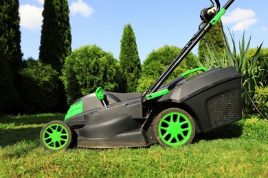 Lawn mower on green grass in garden