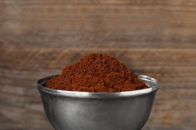 Photo of Ground coffee against wooden background, closeup view