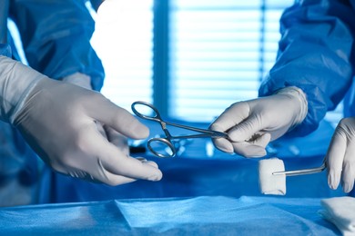 Photo of Professional surgeons with instruments performing operation in clinic, closeup