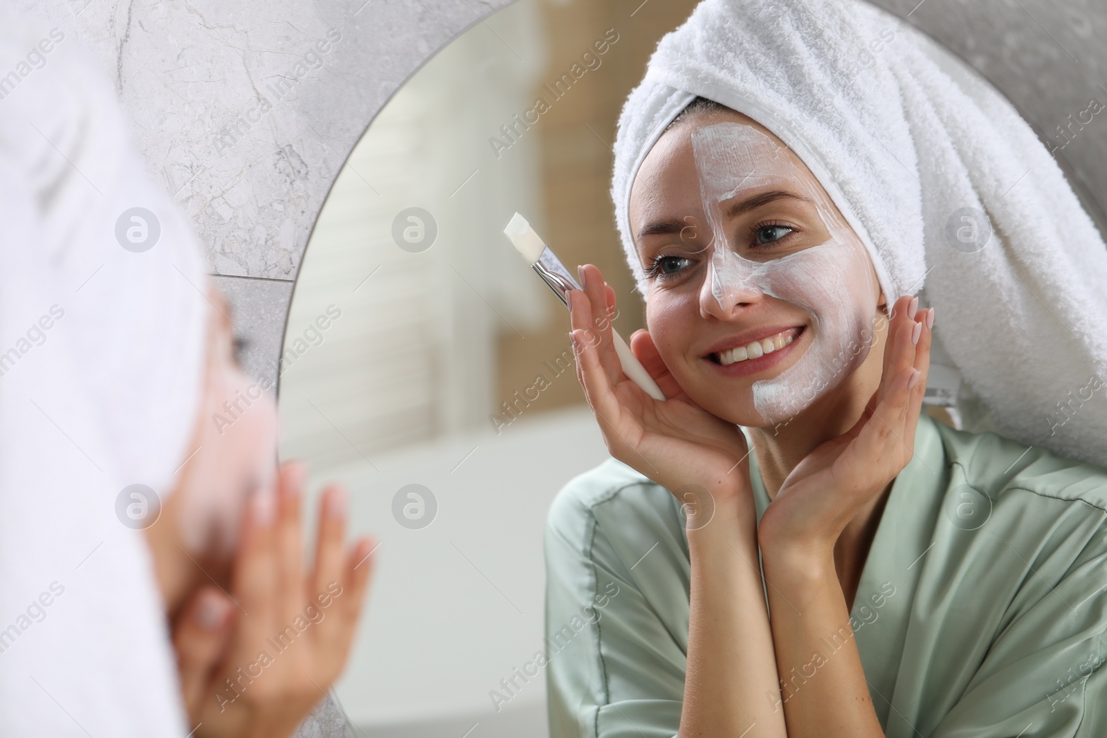 Photo of Woman with face mask in front of mirror indoors. Spa treatments