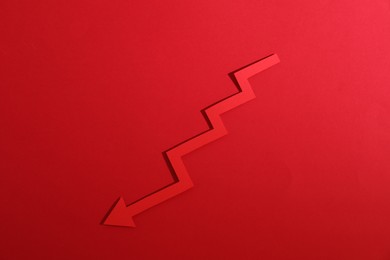 One zigzag paper arrow on red background, top view