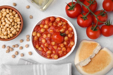 Photo of Delicious chickpea curry with flatbread on light gray table, flat lay