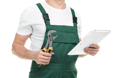 Young plumber with tablet computer and adjustable wrench on white background