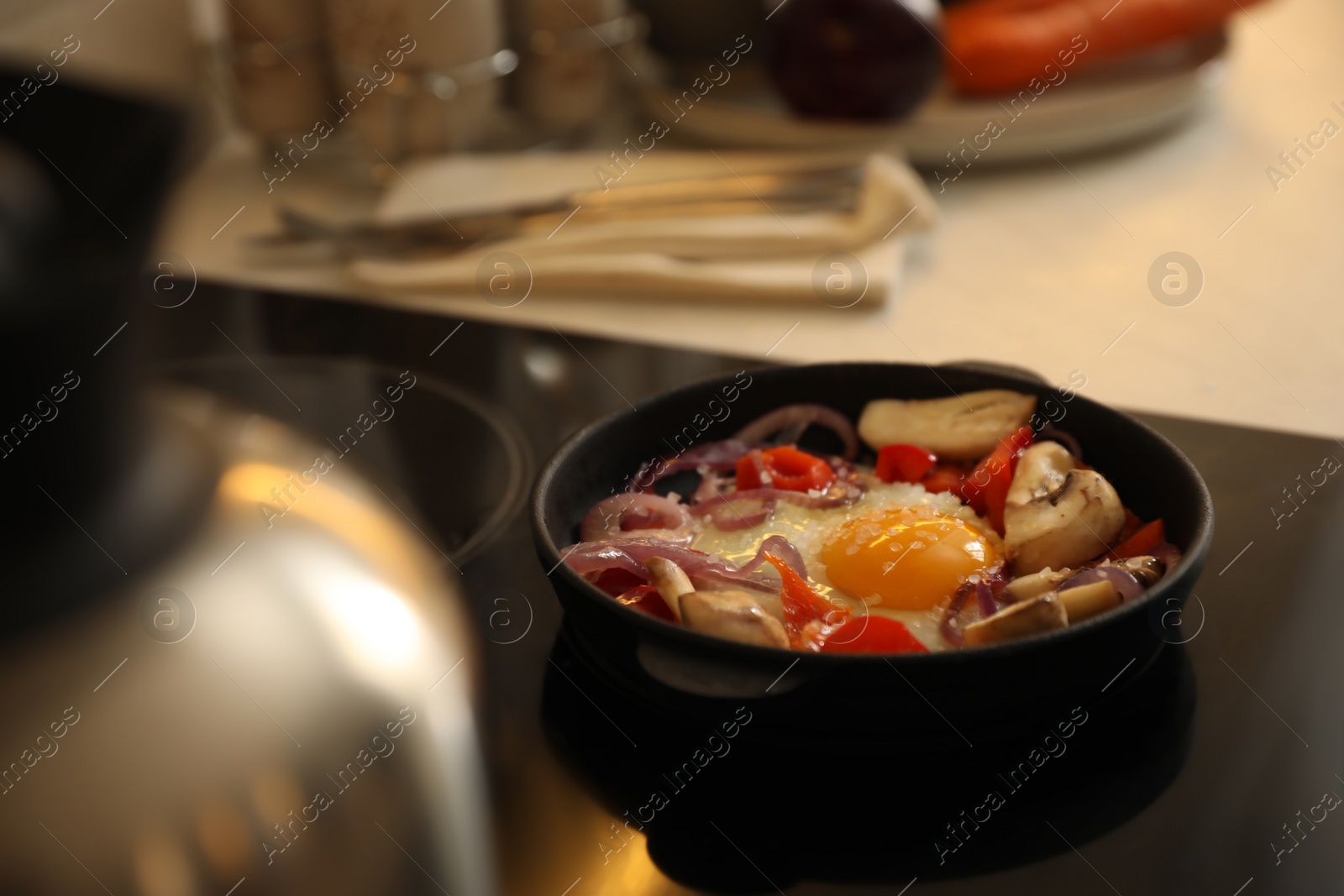 Photo of Frying pan with tasty egg and vegetables on stove, space for text