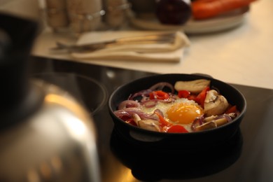 Photo of Frying pan with tasty egg and vegetables on stove, space for text