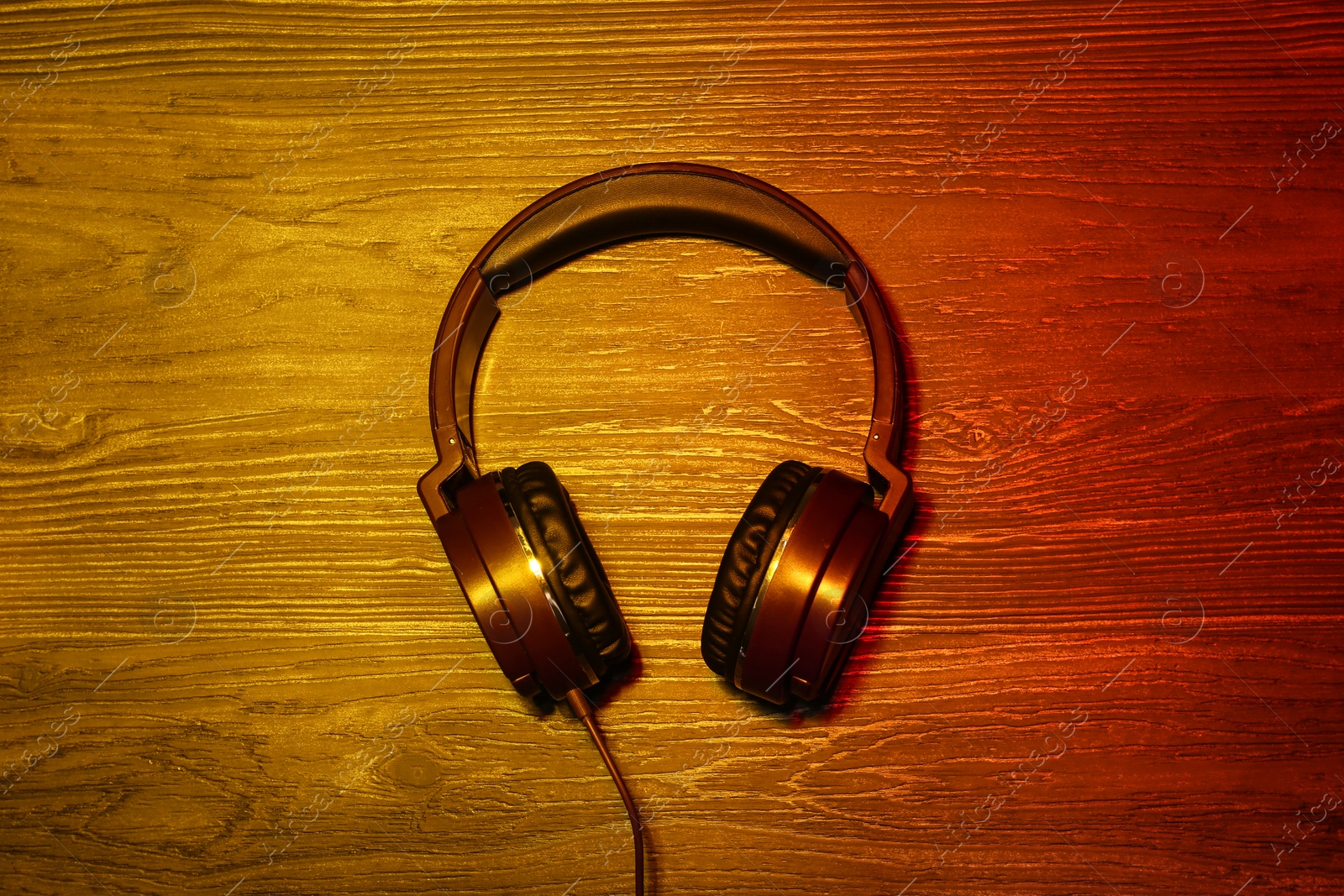 Photo of Stylish headphones on wooden background, top view