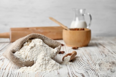 Photo of Sack with flour on wooden table