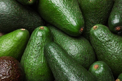 Tasty ripe green avocados as background, closeup