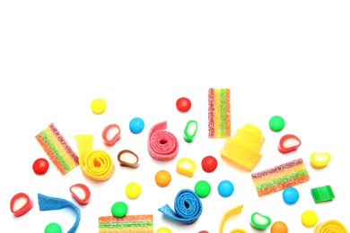 Photo of Many different yummy candies on white background, top view. Space for text