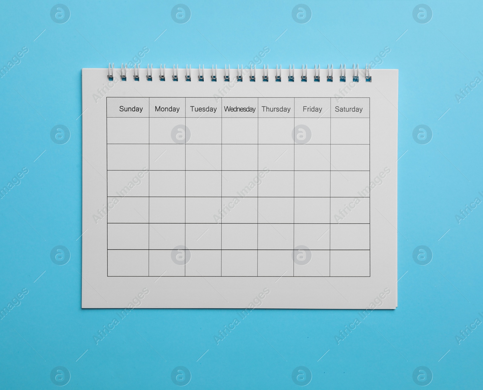Photo of Blank calendar on light blue background, top view