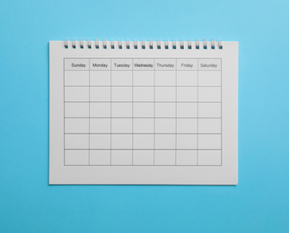 Blank calendar on light blue background, top view