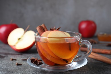 Aromatic hot mulled cider on grey table