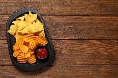 Photo of Tasty tortilla and ridged chips with ketchup on white wooden table, top view. Space for text