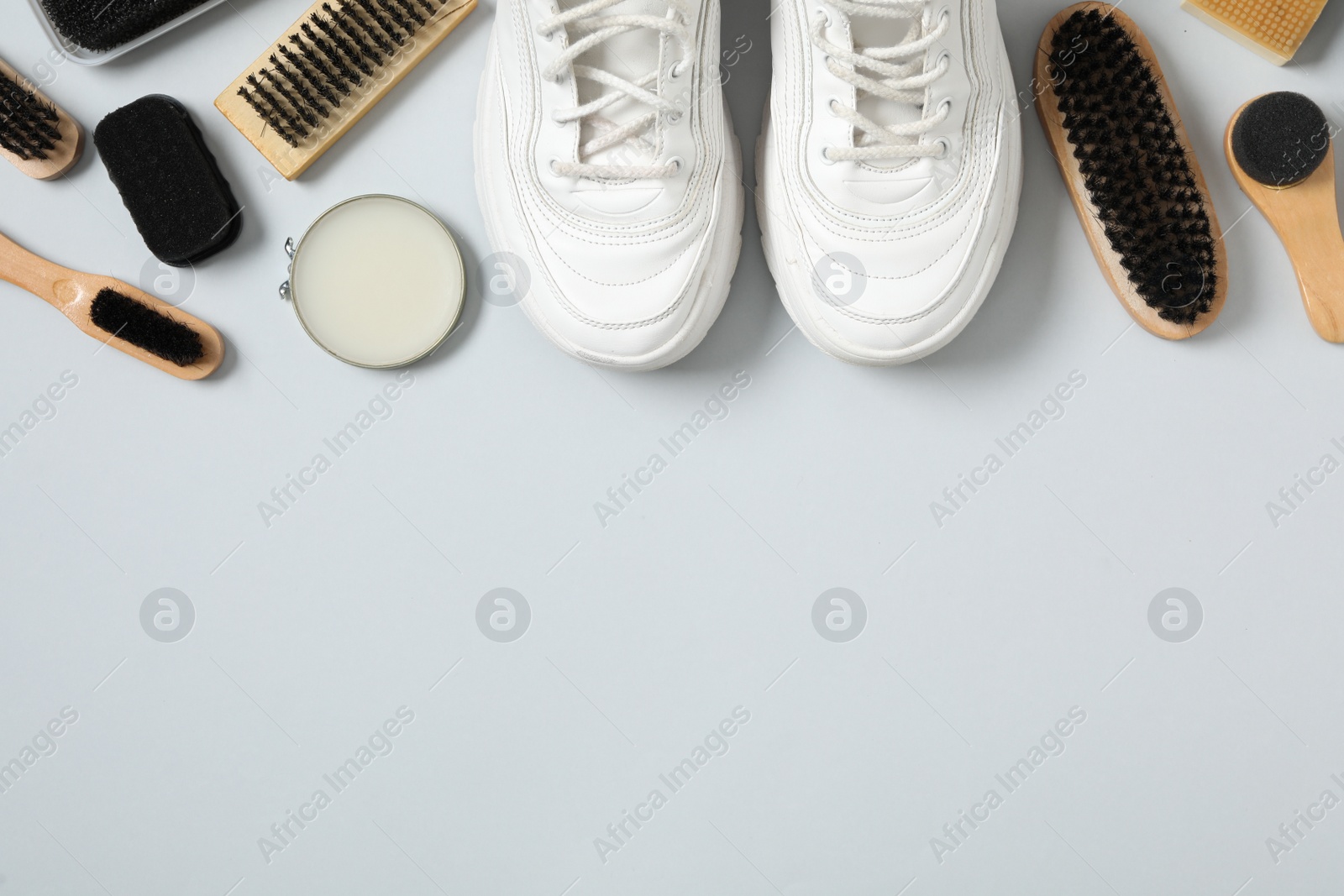 Photo of Flat lay composition with stylish footwear and shoe care accessories on white background, space for text