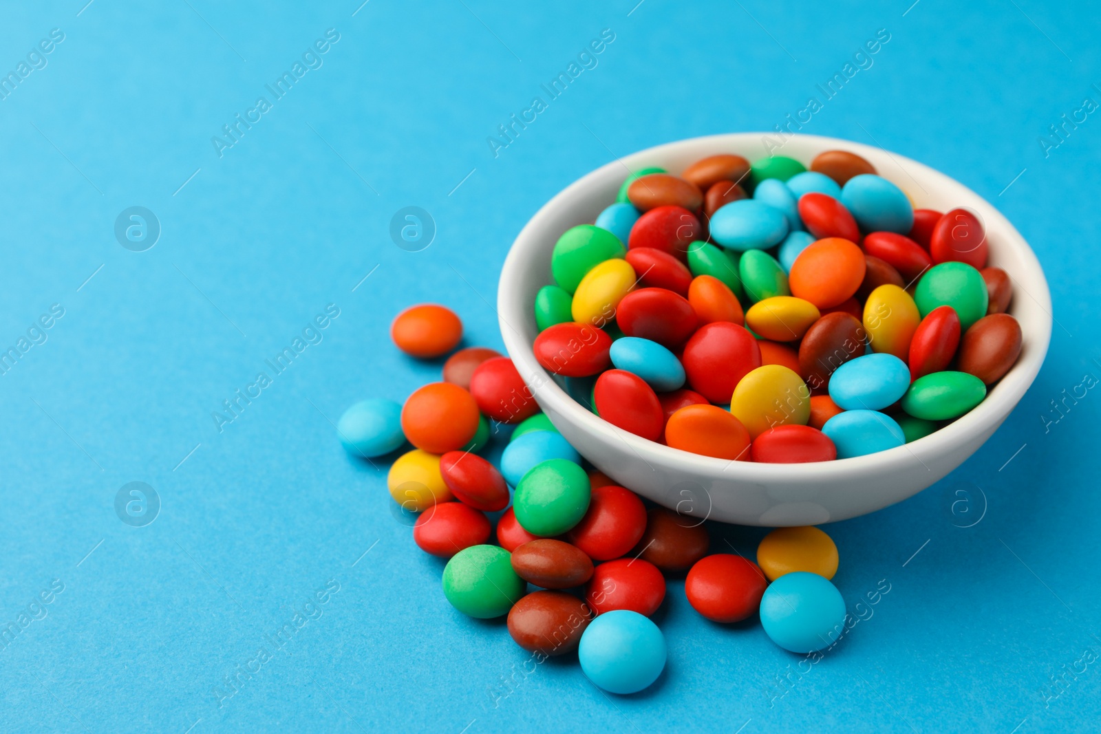 Photo of Tasty colorful candies on blue background, closeup. Space for text