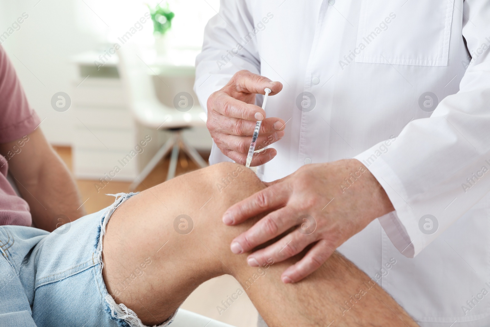 Photo of Doctor giving patient injection in clinic, closeup. Knee problem treatment