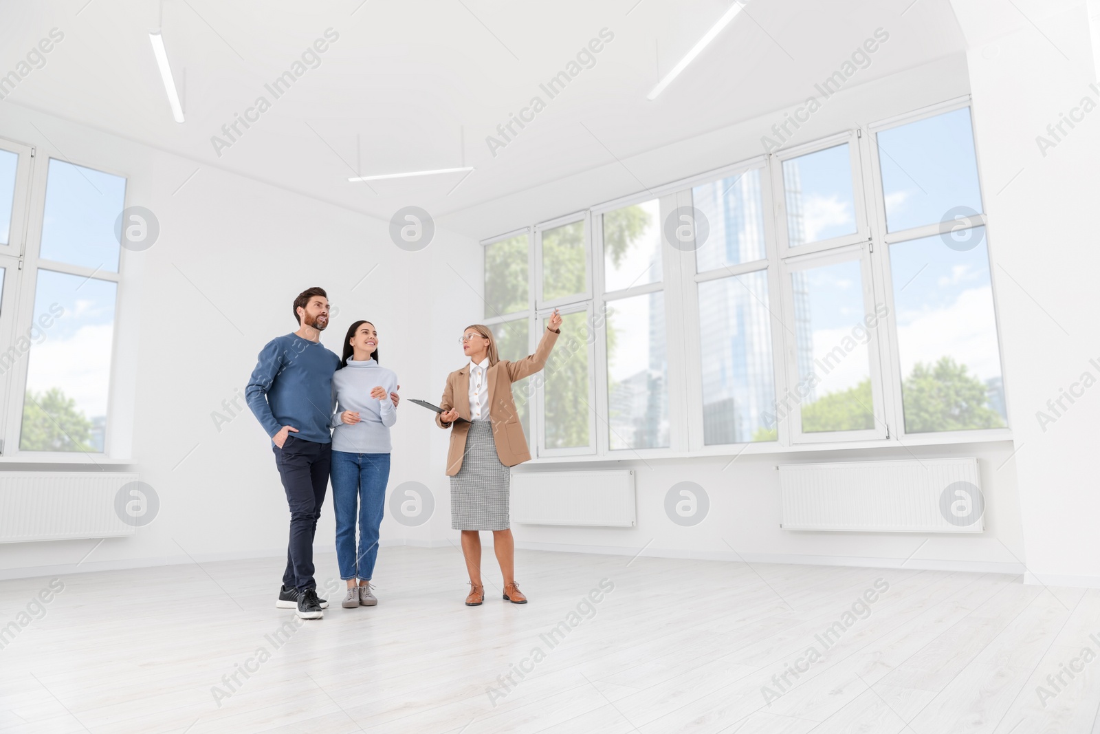 Photo of Real estate agent showing new apartment to couple