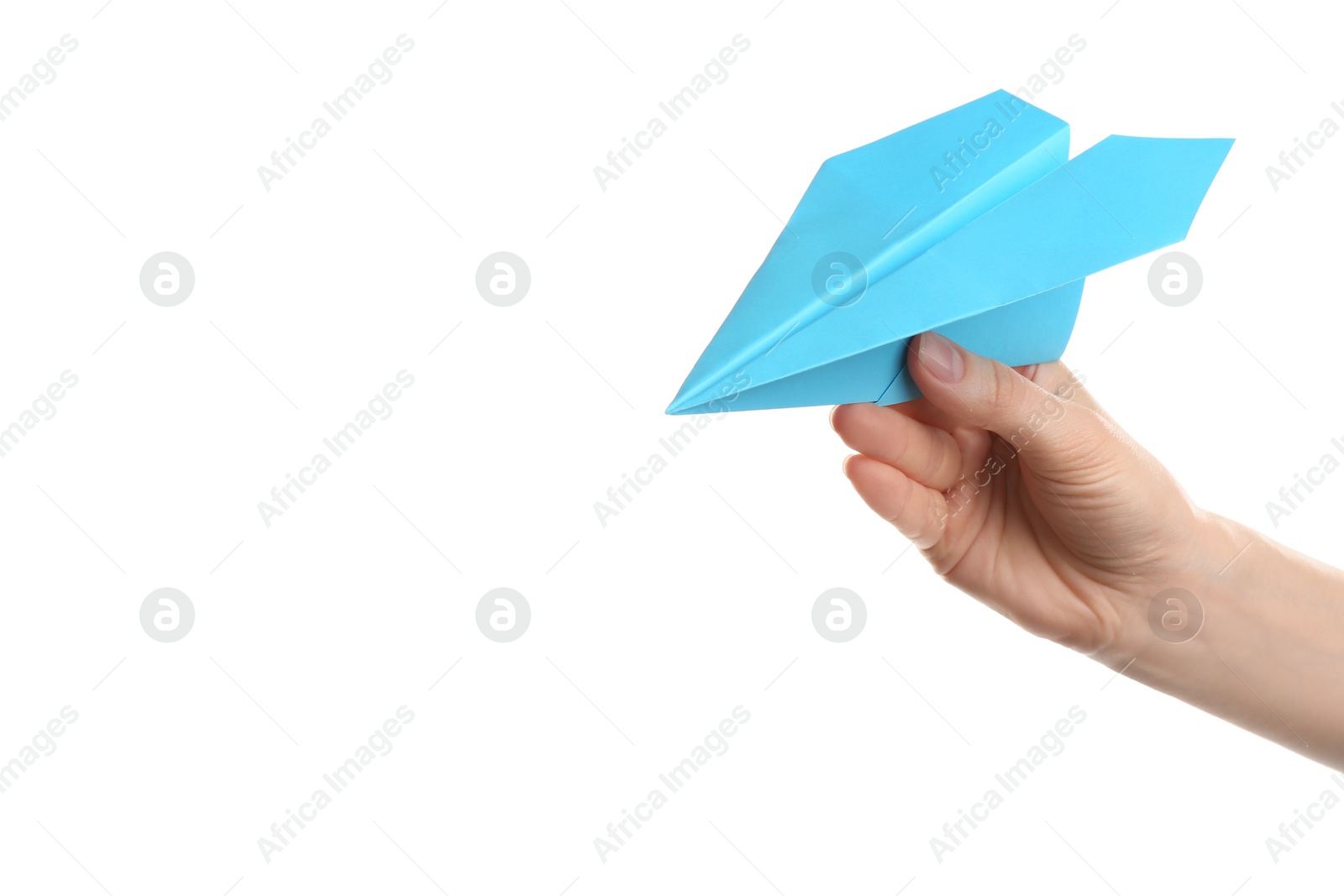 Photo of Woman holding light blue paper plane on white background, closeup