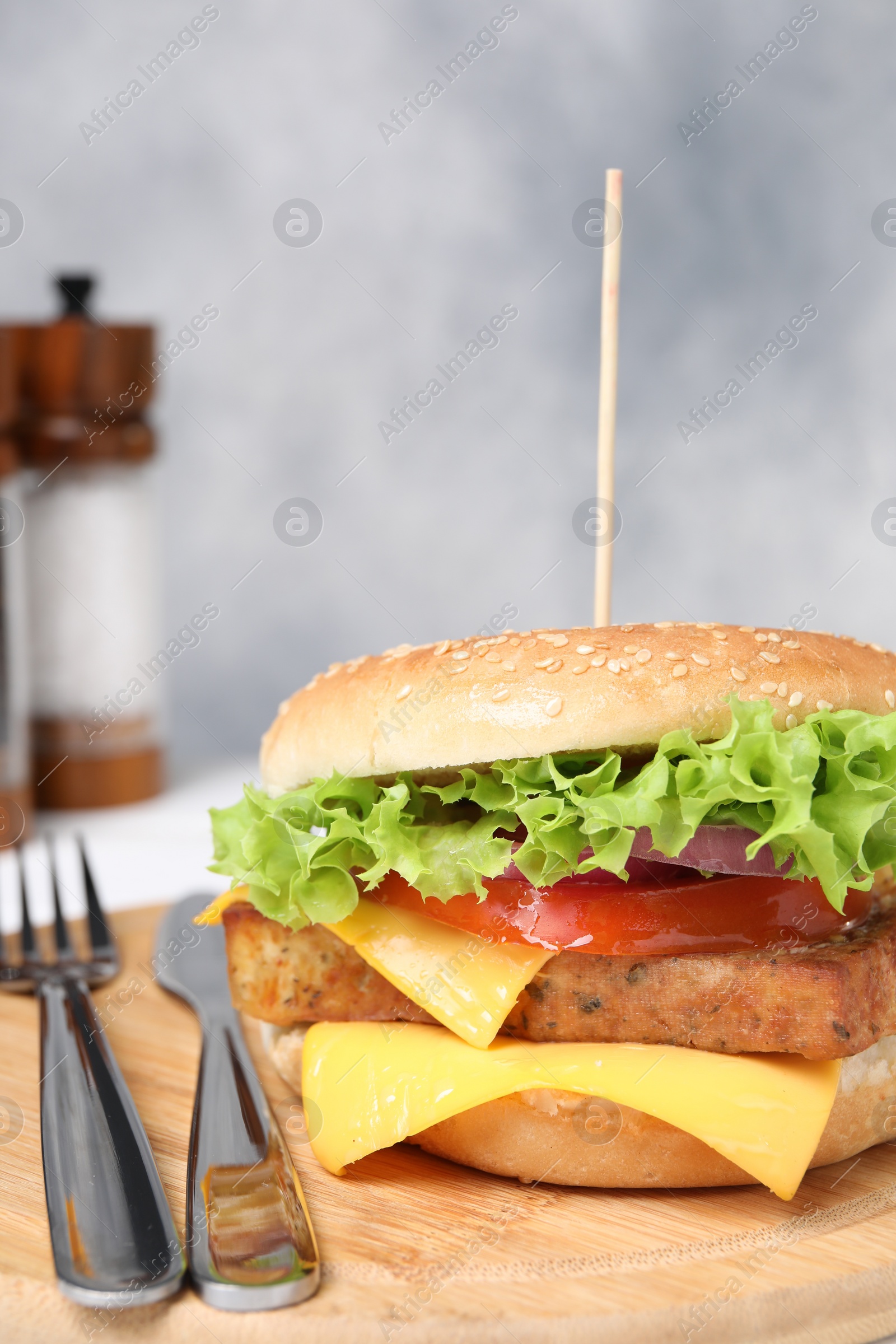 Photo of Delicious burger with tofu and fresh vegetables served on white table