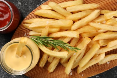Delicious french fries served with sauces on grey textured table, flat lay