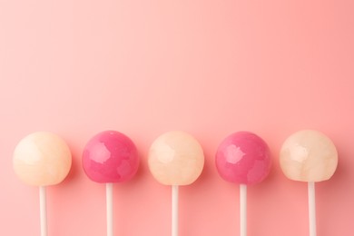 Tasty lollipops on pink background, flat lay. Space for text