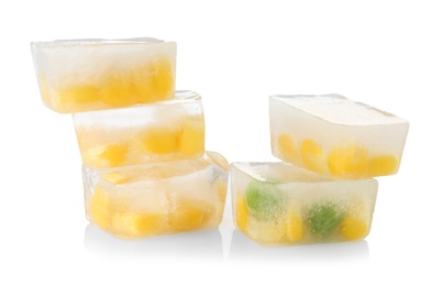 Photo of Corn grains and green peas in ice cubes on white background. Frozen vegetables