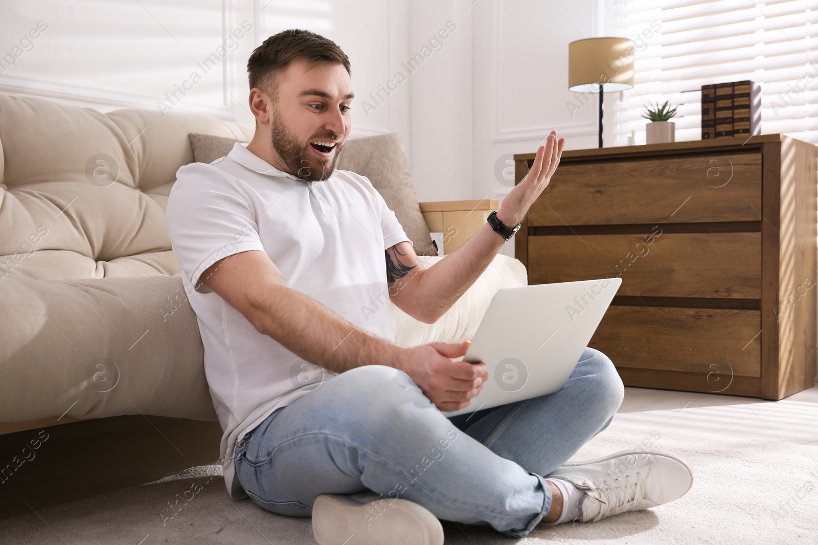 Photo of Emotional man participating in online auction using laptop at home