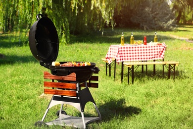 Modern barbecue grill with tasty food in park