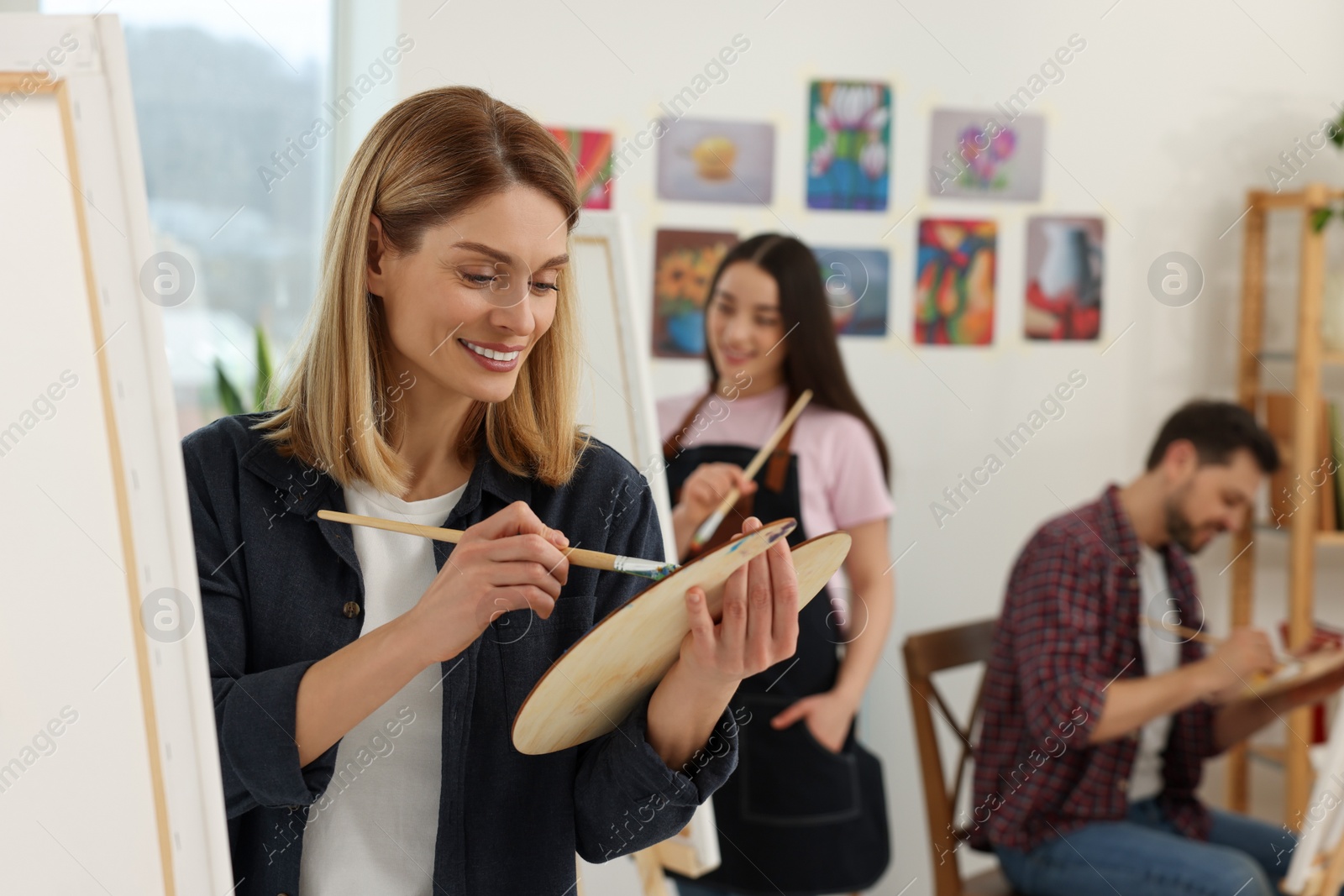 Photo of Group of students attending painting class in studio. Creative hobby