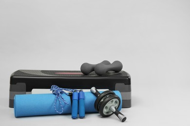 Photo of Step platform and other sport equipment on light background. Space for text