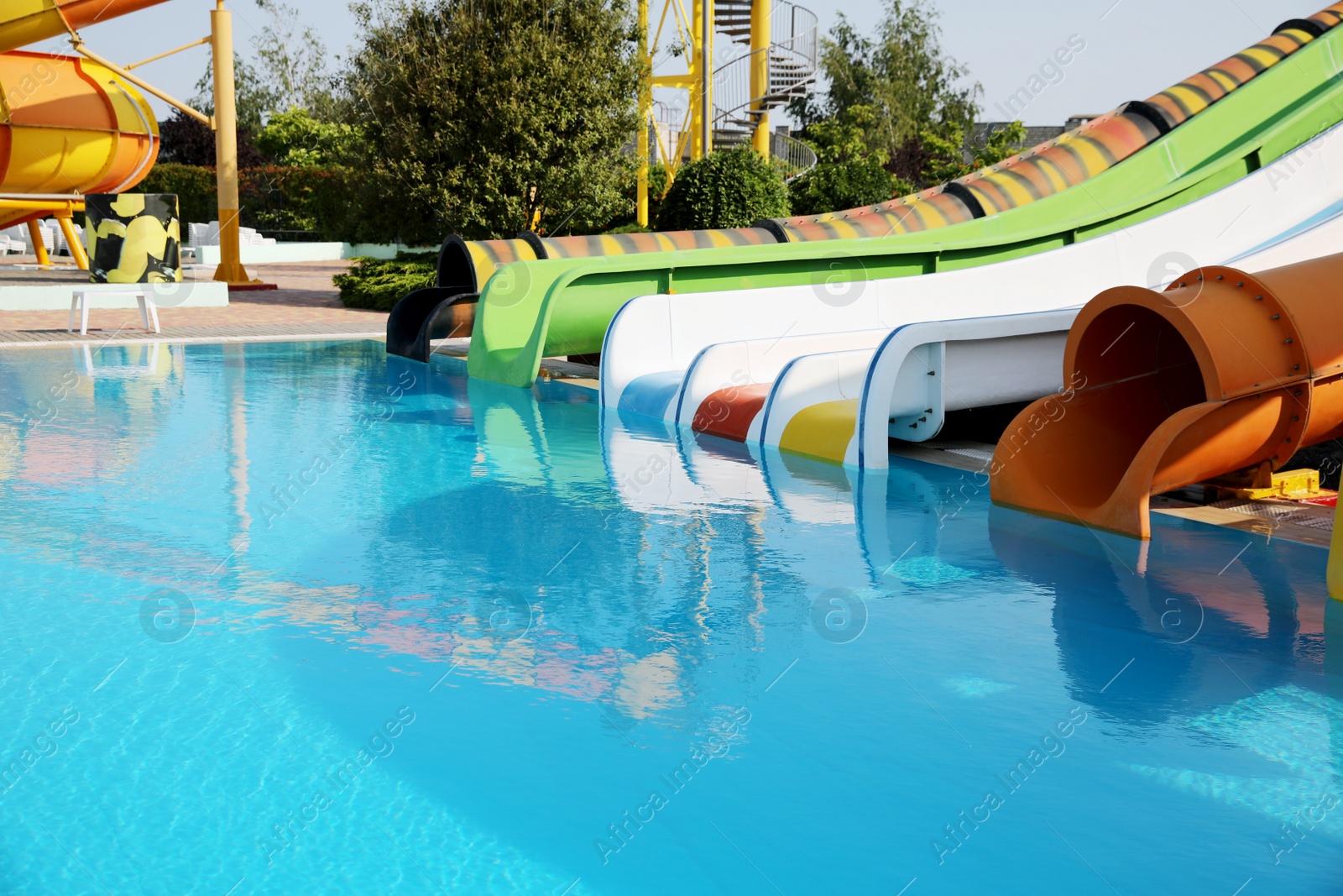 Photo of Beautiful view of water park with colorful slides and swimming pool on sunny day