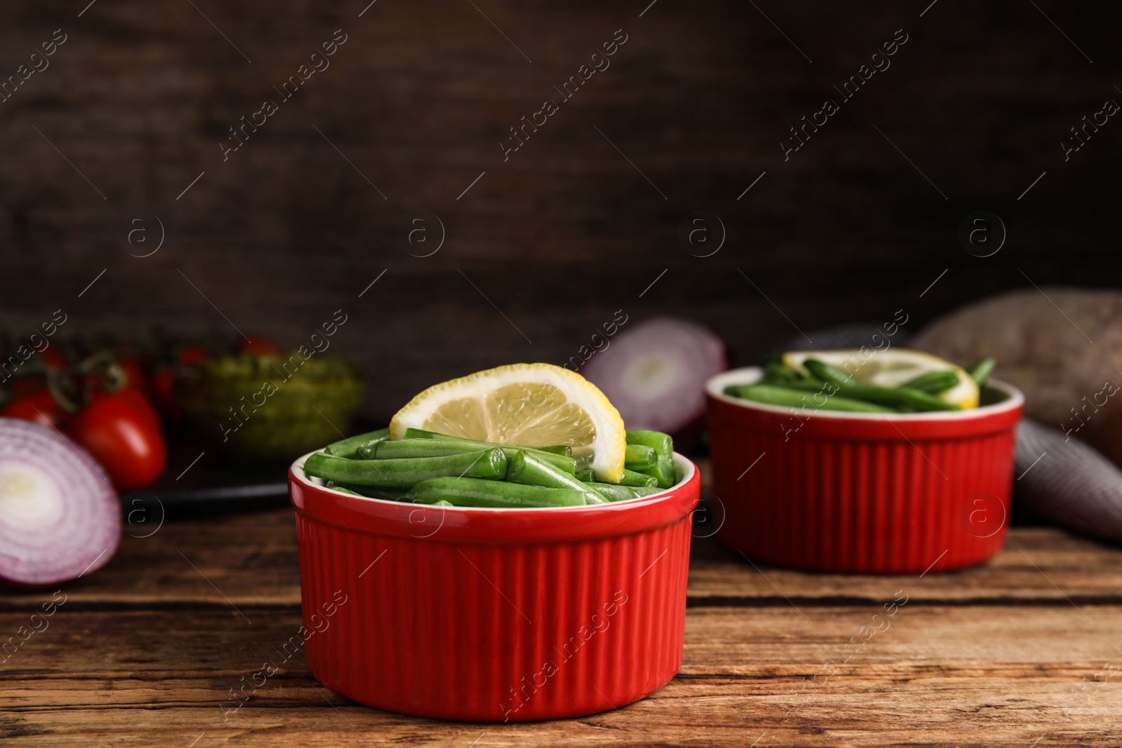 Photo of Raw green beans with lemon on wooden table
