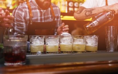 Photo of Glasses of tasty cocktail on bar counter