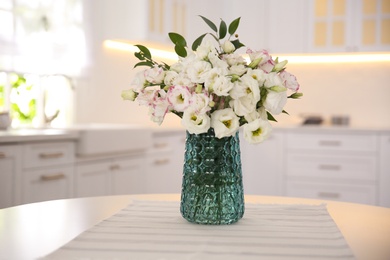 Bouquet of beautiful flowers on table in kitchen. Interior design