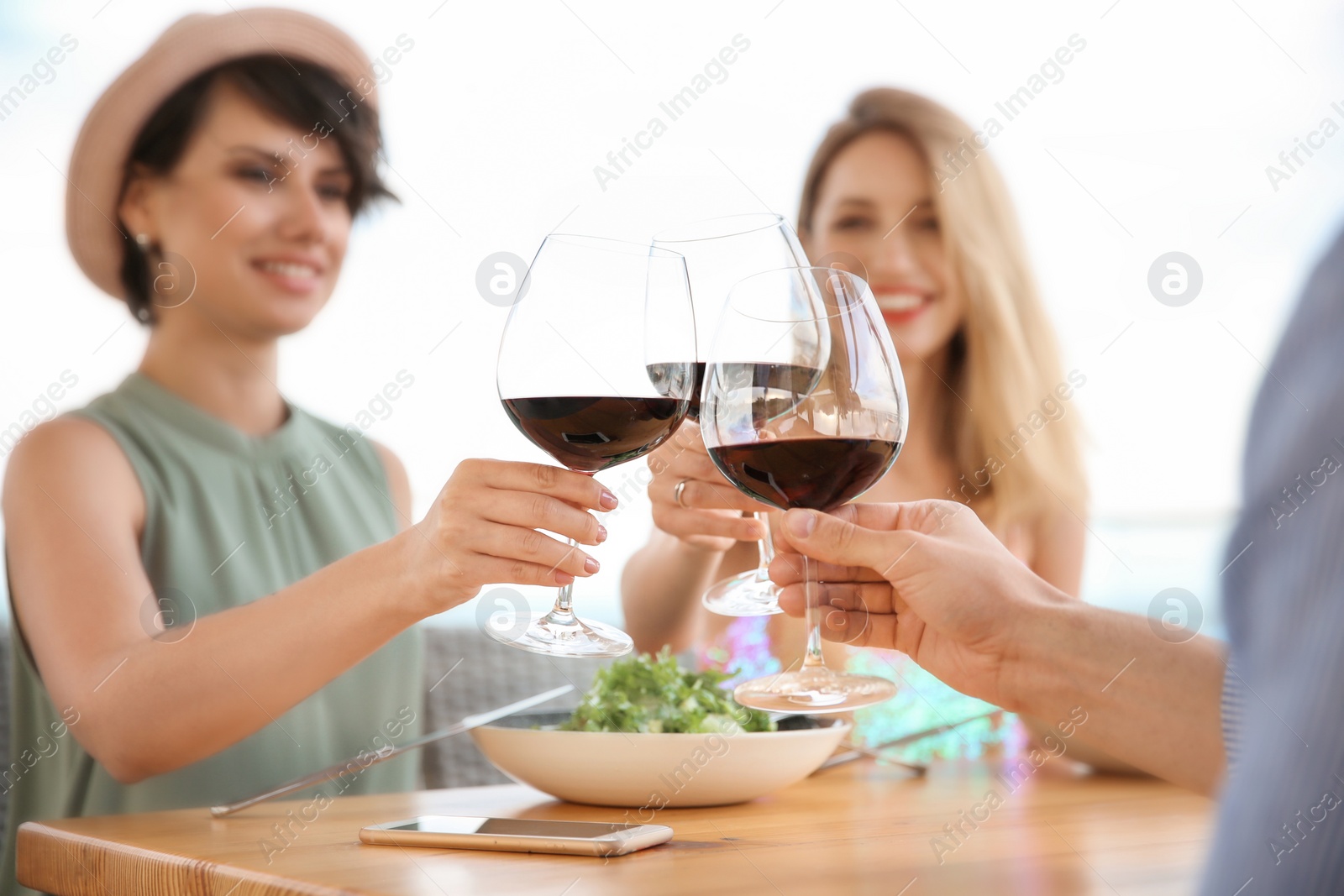 Photo of Group of friends with glasses of wine at table