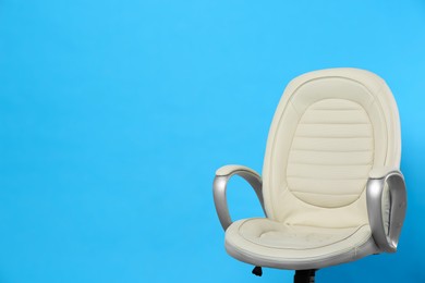 Photo of Comfortable office chair on light blue background, space for text